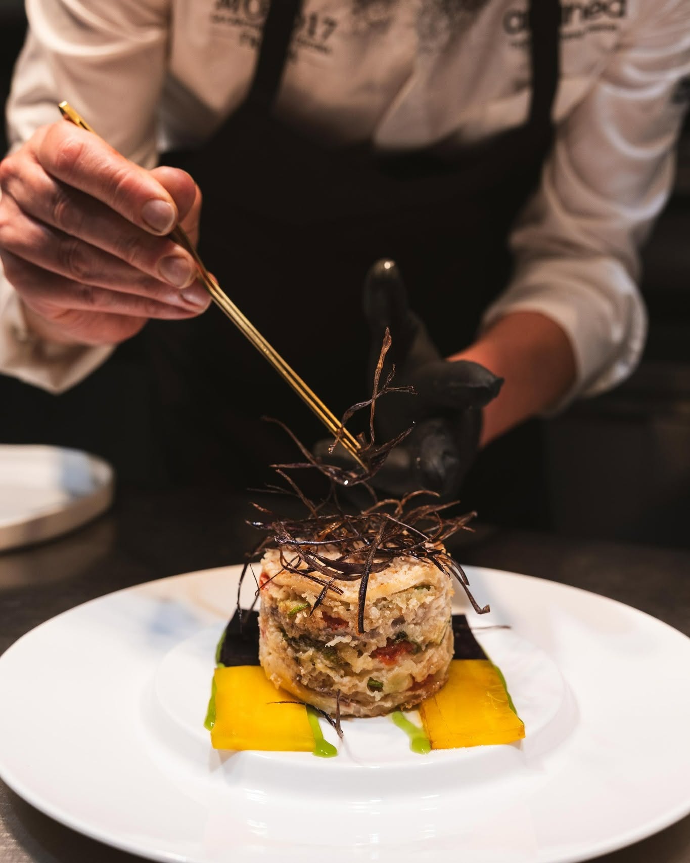 Le mani dello chef rifiniscono un piatto